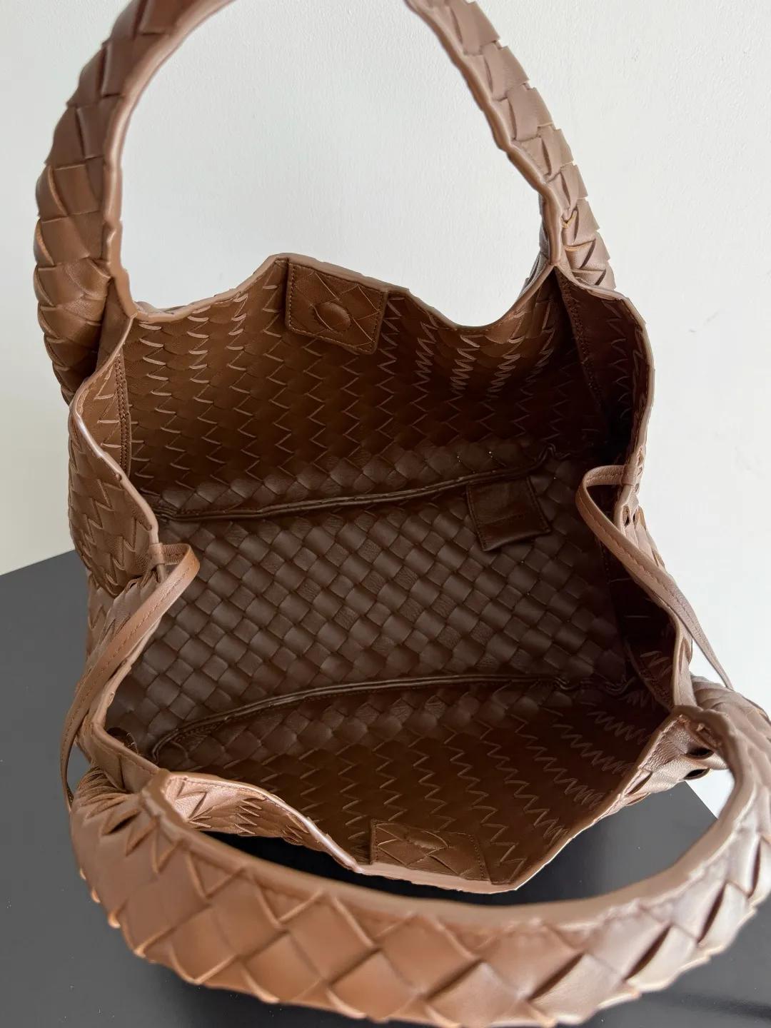 Batch 2160 new products are coming! BOTTEGA VENETA Bottega Veneta's 2025 new Campana shoulder bag is on the market~ First of all, I would like to praise the weight of this bag. As a not too small bag, it is very light for daily use. For people like me who need to carry a lot of belongings when going out, this advantage is great, and it greatly reduces the burden of traveling. 🛍️The shape is a bit like a combination of parachute and jodie. The blunt triangle shape is cute and honest. Carrying it on your back when going shopping is a good mood accelerator. The handles and body of the bag are both classic weaves. A tie is added to the original open design. If it is not tied up, the bag will look like a small vegetable basket when carried. Style number: 844249 Size: 33*20*16.5cm
